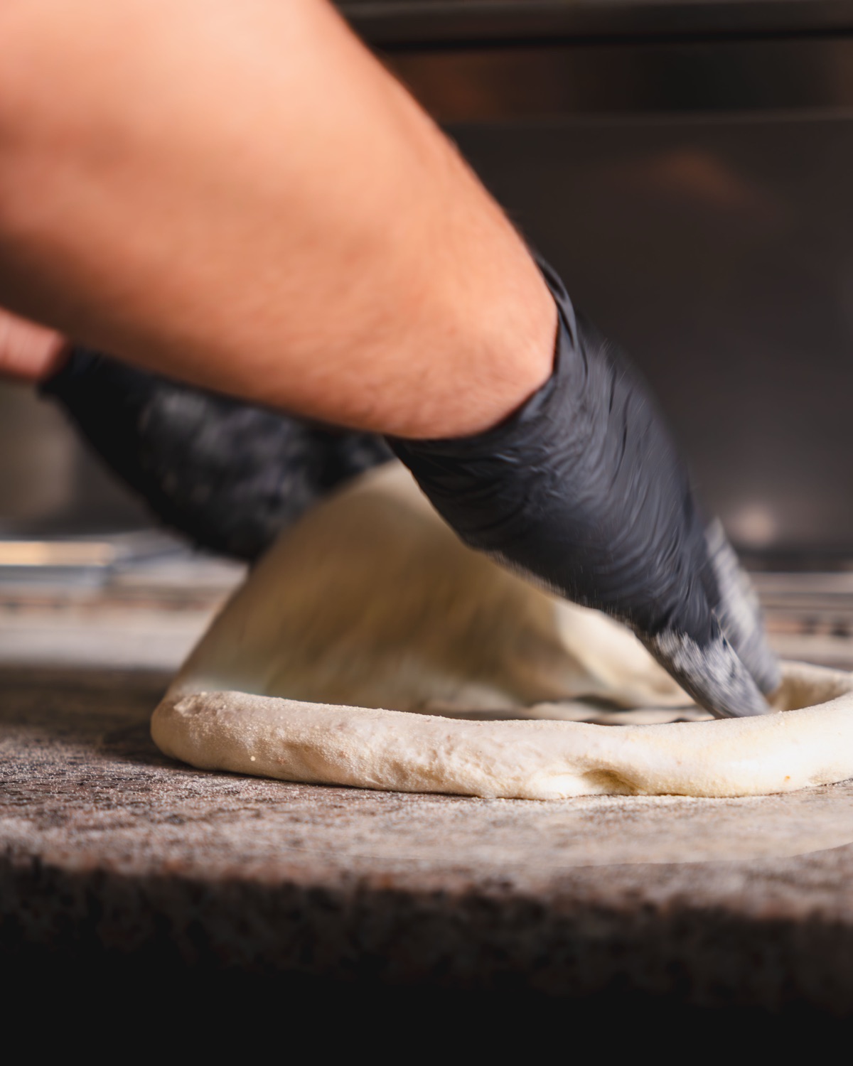Pizzaiolo venyttää taikinaa käsin